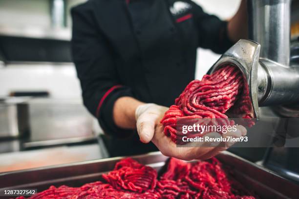 carnicería de chef macho haciendo carne molida fresca en el molinillo de carne - trituradora de carne fotografías e imágenes de stock