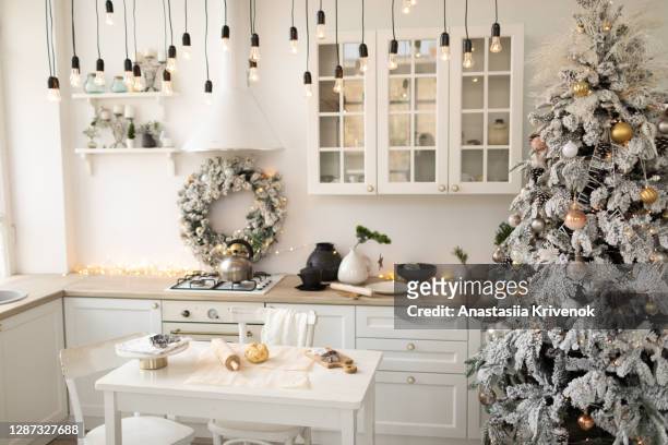 interior white kitchen with christmas decor and decorated fir tree. - food white background foto e immagini stock