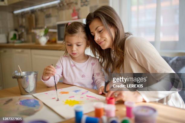mother and daughter paint with colorful paints at home - eastern europe stock pictures, royalty-free photos & images