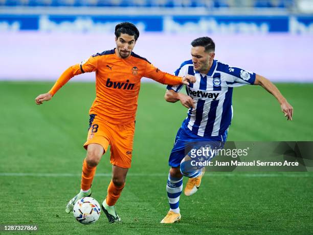 Lucas Perez of Deportivo Alaves duels for the ball with Carlos Soler of Valencia CF during the LaLiga Santander match between Alaves and Valencia on...