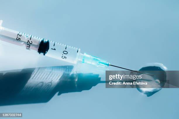 clean syringe releasing transparent vaccine - dosing stock-fotos und bilder