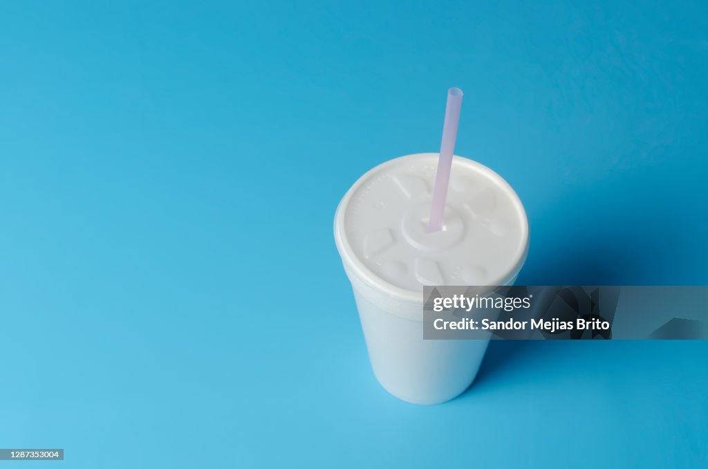 Insulated disposable plastic cup on blue background