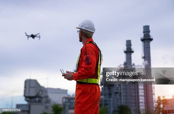 engineer piloting drone at building site - camera operator stock pictures, royalty-free photos & images