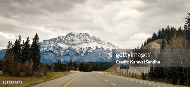 trans canada highway cutting across nature reserve with mt rundle peak in background - monte rundle - fotografias e filmes do acervo