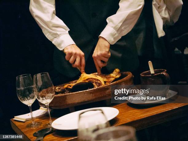 waiter cutting grilled piglet - segovia stock pictures, royalty-free photos & images