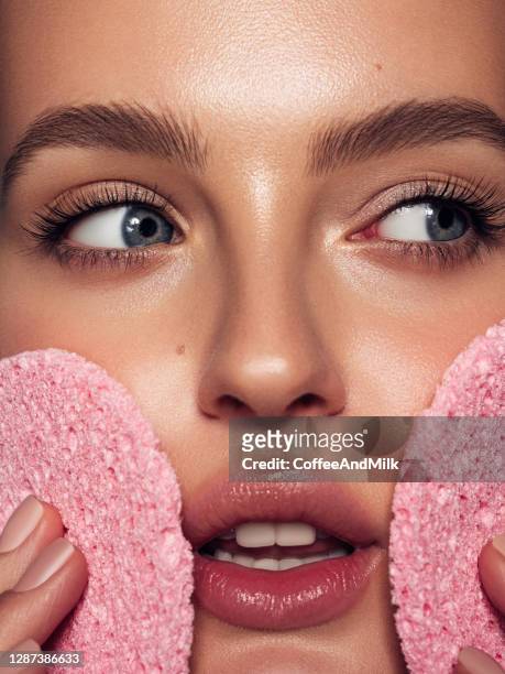 de jonge vrouw reinigt de huid natuurlijke spons - pores stockfoto's en -beelden
