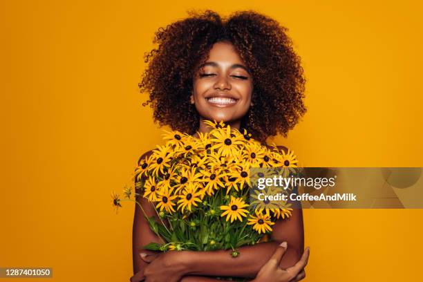 beautiful afro woman with bunch of flowers - flower woman stock pictures, royalty-free photos & images