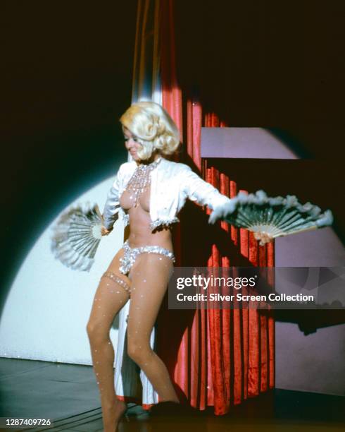 Puerto Rican actress, singer and dancer Rita Moreno as Dolores Gonzales, performing a striptease in the neo-noir film 'Marlowe', 1969.