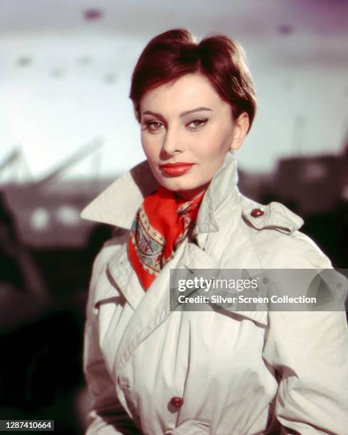 Italian actress Sophia Loren in a trench coat and scarf during the filming of 'The Key', 1958.