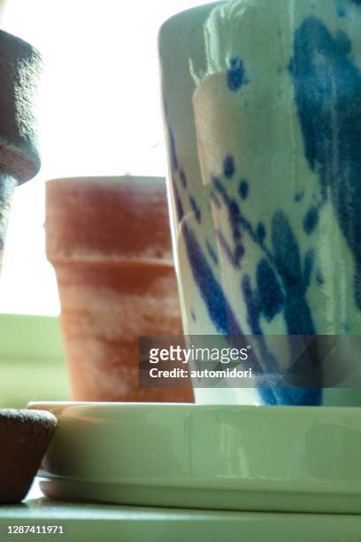 close up on a planter pot with blue patterns - untertasse stock-fotos und bilder