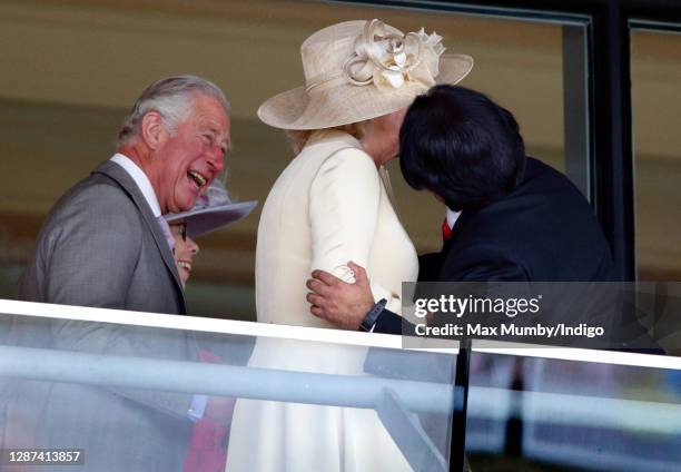 Prince Charles, Prince of Wales looks on as Sanjeev Bhaskar greets Camilla, Duchess of Cornwall on day 1 of Royal Ascot at Ascot Racecourse on June...