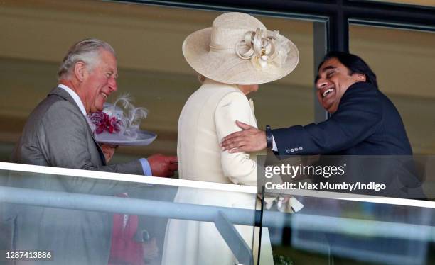 Prince Charles, Prince of Wales looks on as Sanjeev Bhaskar greets Camilla, Duchess of Cornwall on day 1 of Royal Ascot at Ascot Racecourse on June...