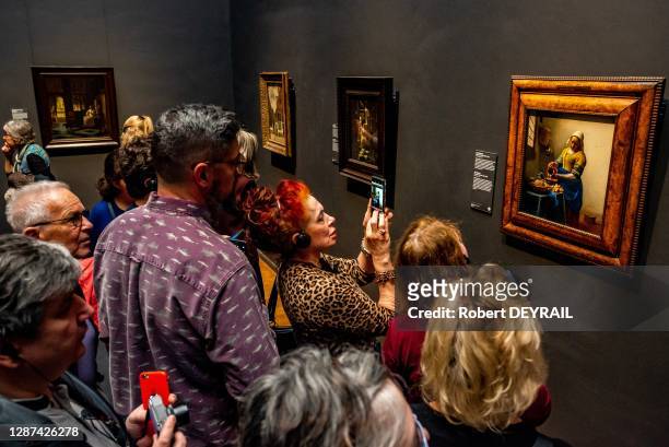 Visiteurs photographiant avec leurs téléphones portables le tableau "La Laitière "de Vermeer exposée au Rijksmuseum, le 26 avril 2018 à Amsterdam,...