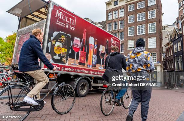 Cyclistes et camion de livraison de bières dans la circulation, 24 avril 2018, Amsterdam, Pays-Bas.