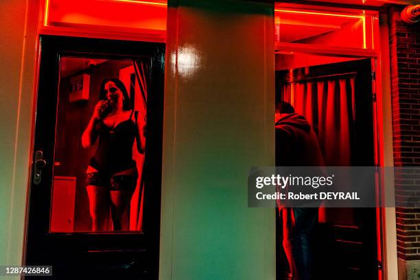 Travailleuse du sexe et client dans les vitrines du Quartier Rouge , 25 avril 2018 Amsterdam, Pays-Bas.