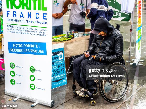 Un handicapé en fauteuil roulant lit une brochure d'information de la société NORML prônant l'usage du cannabis à des fins thérapeutiques lors de la...