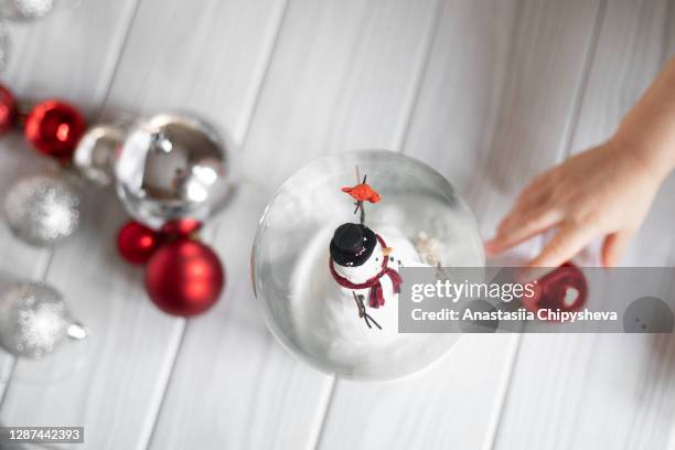 children's hand taking christmas decoration - funny snow globe stock pictures, royalty-free photos & images