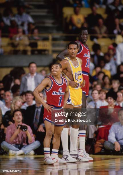 Muggsy Bogues, Point Guard for the Washington Bullets stands beside Billy Thompson of the Los Angeles Lakers and team mate Manute Bol during their...