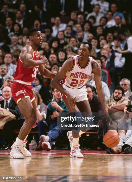 John Salley, Power Forward for the Detroit Pistons dribbles the basketball downcourt challenged by Otis Thorpe, Center for the Houston Rockets during...