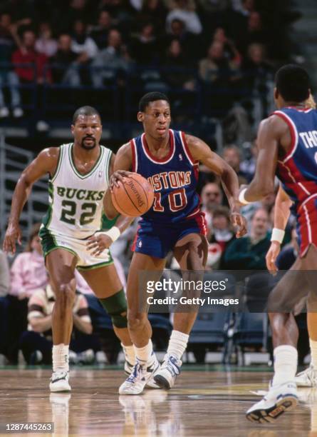 Dennis Rodman, Power Forward for the Detroit Pistons dribbles the basketball as Ricky Pierce of the Milwaukee Bucks looks on during the NBA Central...