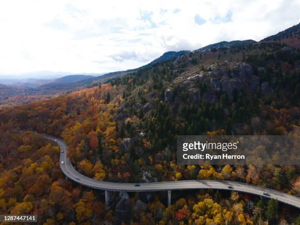 aerial of a winding highway through a forest in autumn - blue ridge parkway stock pictures, royalty-free photos & images