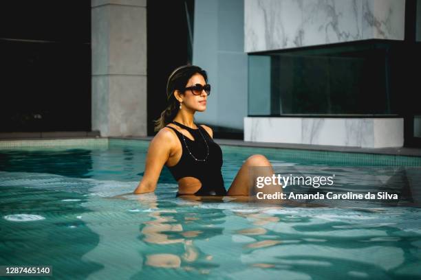 femmes appréciant la piscine de luxe - courtisane rôle social photos et images de collection