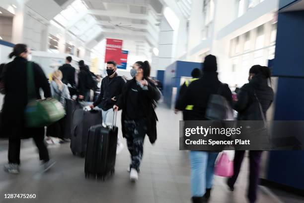 People walk through New York’s LaGuardia Airport on November 24, 2020 in New York City. Despite warnings from the government and politicians not to...