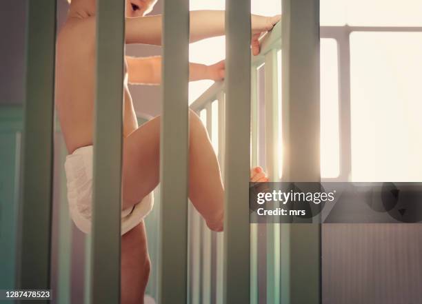 baby standing in crib - baby climbing stock pictures, royalty-free photos & images