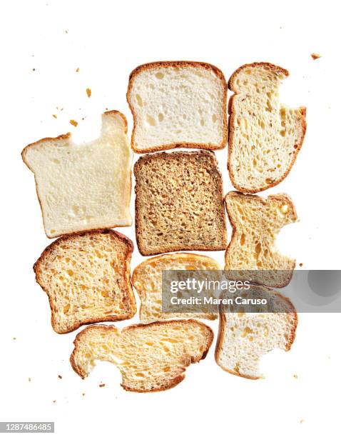 backlit slices of gluten free bread and crumbs - abgebissen stock-fotos und bilder