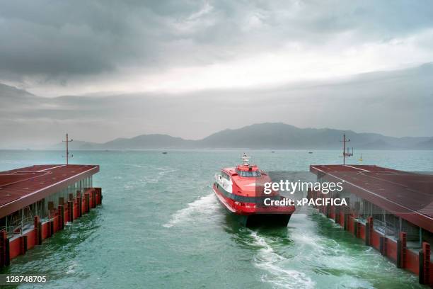 a catamaran ferry docks at a port. - ferry terminal stock pictures, royalty-free photos & images