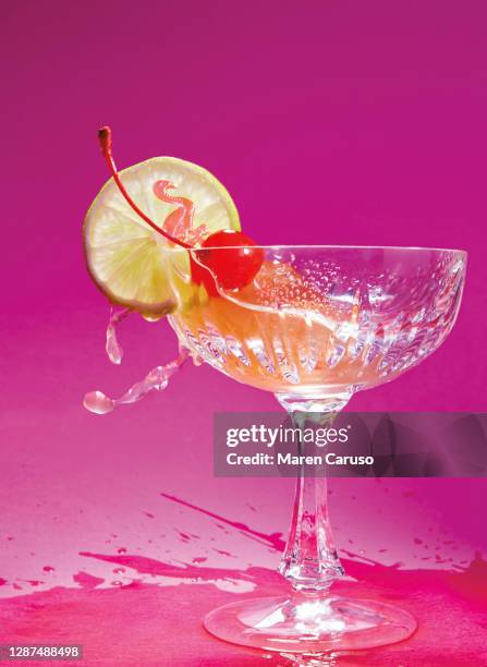 splashing daiquiri on pink surface - pink cocktail lime stock pictures, royalty-free photos & images