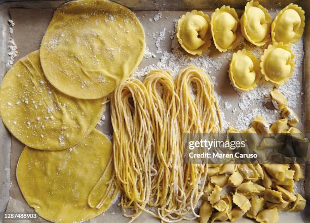 variety of fresh uncooked pastas on baking sheet - sans gluten photos et images de collection