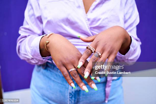 close up of woman's hands with lots of gold rings and painted nails - fingernagel stock-fotos und bilder