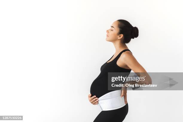 pregnant tired woman in support bandage medical corset. - orthopedic corset stock pictures, royalty-free photos & images