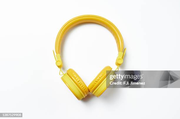 yellow headphones on white background - loud music headphones stock pictures, royalty-free photos & images