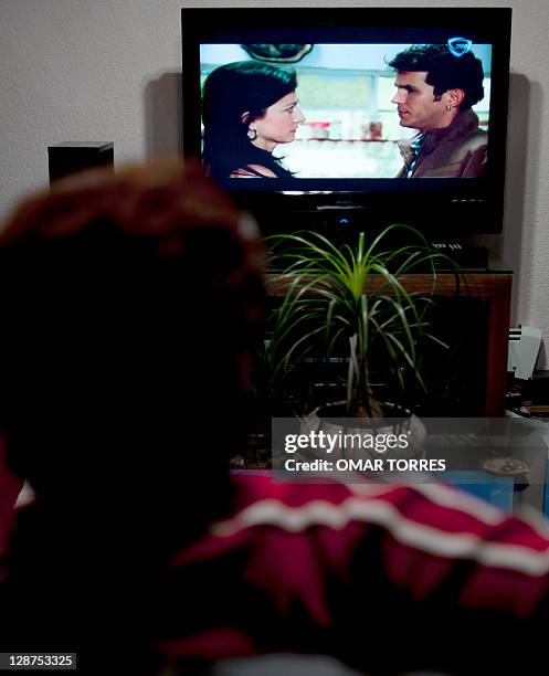 Mexican woman watches on the tele an episode of "El Octavo Mandamiento" soup opera, in Mexico City, on October 6, 2011. Latin American soap operas,...