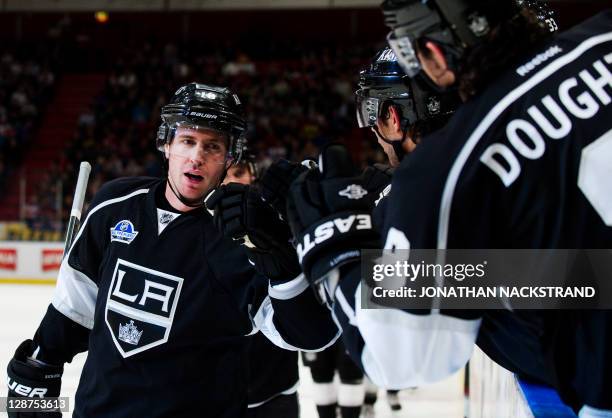 Teammates celebrate with Los Angeles Kings's Mike Richards as he scores against New York Rangers's goalie Henrik Lundqvist at their ice hockey NHL...