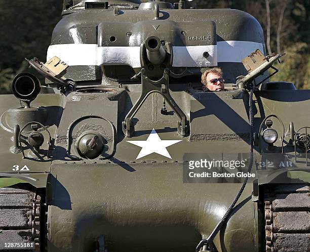 Rob Collings, executive director of the Collings Foundation, has his head out of the hatch in an American WW ll Sherman Tank. The Collings Foundation...