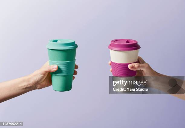 reusable coffee cup in hand - cup stockfoto's en -beelden