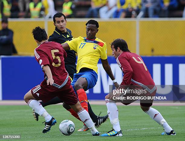 Ecuadorean forward Jaime Ayovi is marked by Venezuelan midfielder Francisco Flores and defender Jose Manuel Velasquez during a Brazil 2014 World Cup...