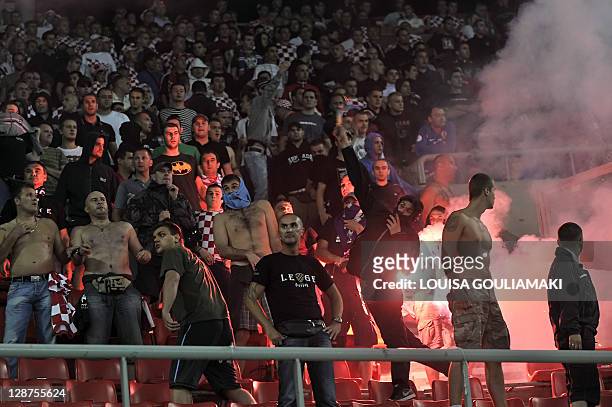 Croatian supporter a flare during clashes as the game was suspended for a few minutes the Euro 2012 qualifying football match Greece vs Croatia at...