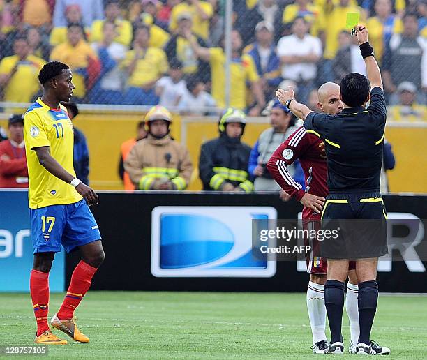 Chilean referee Enrique Osses shows a second yellow card to Venezuelan defender Jose Manuel Rey , next to Ecuadorean forward Jaime Ayovi, during a...