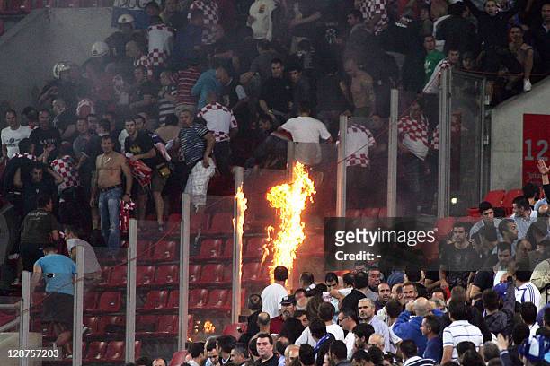 Molotov cocktail is thrown towards Croatian supporters as clashes erupt during the Euro 2012 qualifying football match Greece vs Croatia at the...