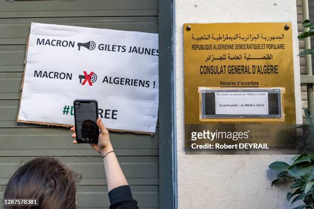 Affiche demandant à Emmanuel Macron de ne pas s'occuper des algériens collée à coté de la plaque du Consulat d''Algérie lors d'une manifestation dans...