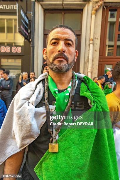 Un homme drapeau algérien sur les épaules porte autour du cou un cadenas, symbole de la fermeture des grilles de l'université d'Alger lors d'une...