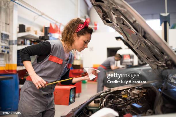 couple of workers each check the oil level of the cars - dipstick stock pictures, royalty-free photos & images