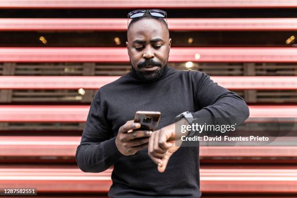 portrait of a young afro businessman - lateral portrait looking mobile photos et images de collection