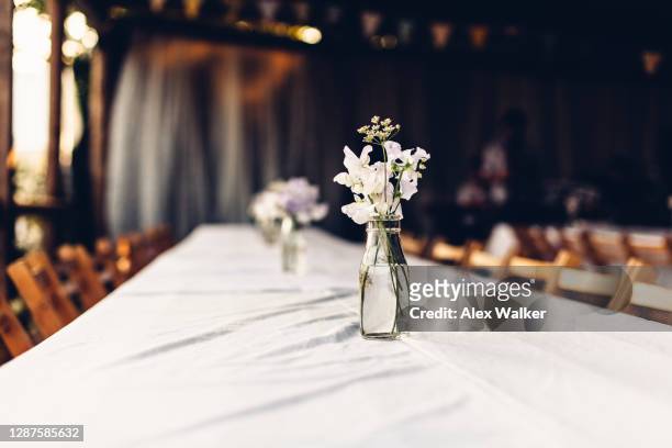 vase with small bunch of flowers on white table - wedding table setting stock-fotos und bilder