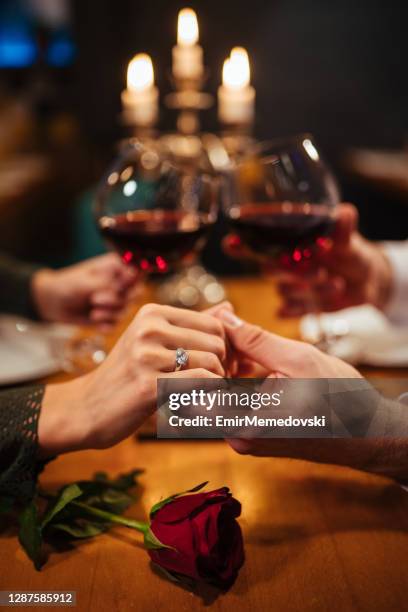 pareja cogidos de la mano durante la cena romántica en un restaurante - mesa para dos fotografías e imágenes de stock