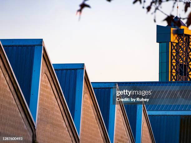 minimal industrial geometric pattern with blue roof tops - gezahnt stock-fotos und bilder